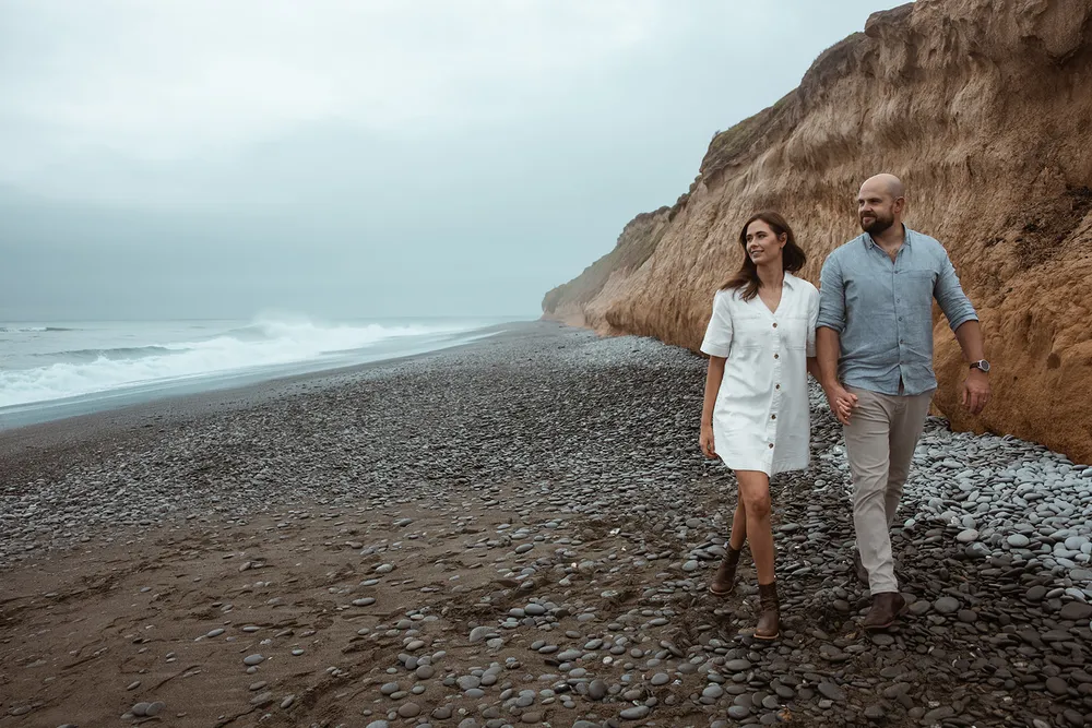 Couple walking along a South Canterbury beach at dusk